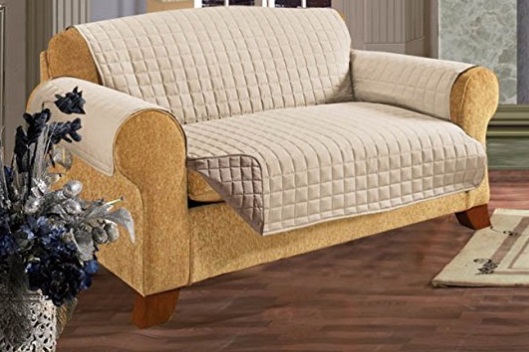 A large sofa covered with a beige furniture protector 
