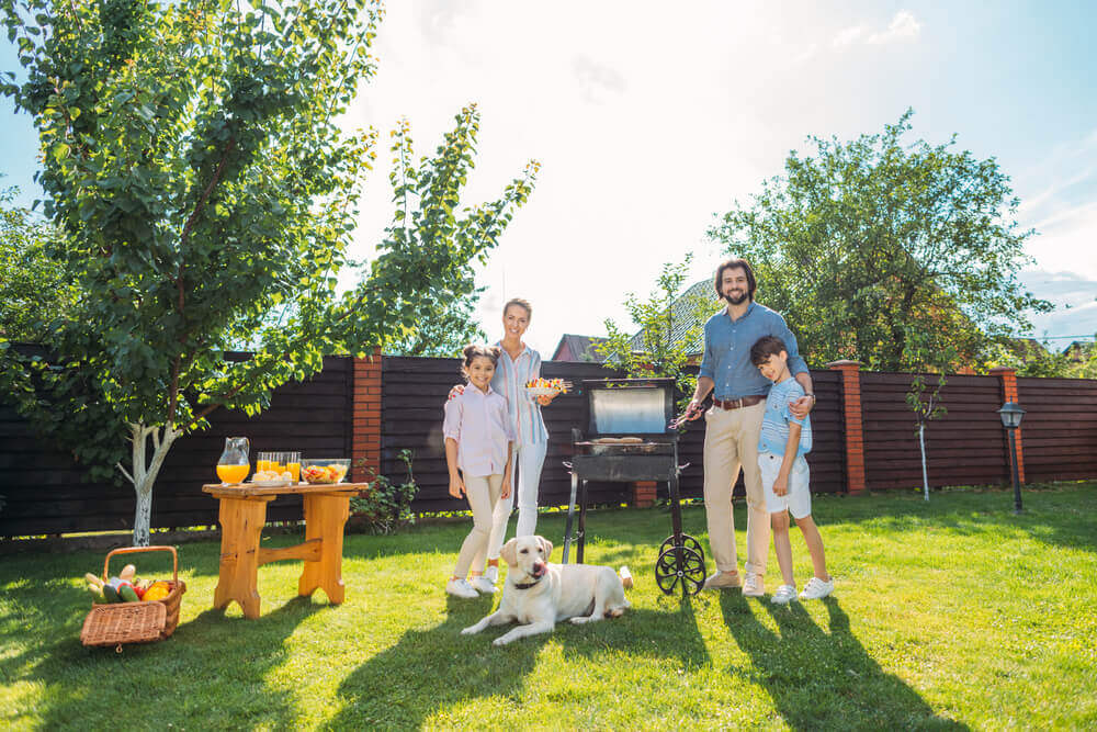 Pet Safety - A Family with dog having barbecue together on backyard on summer day